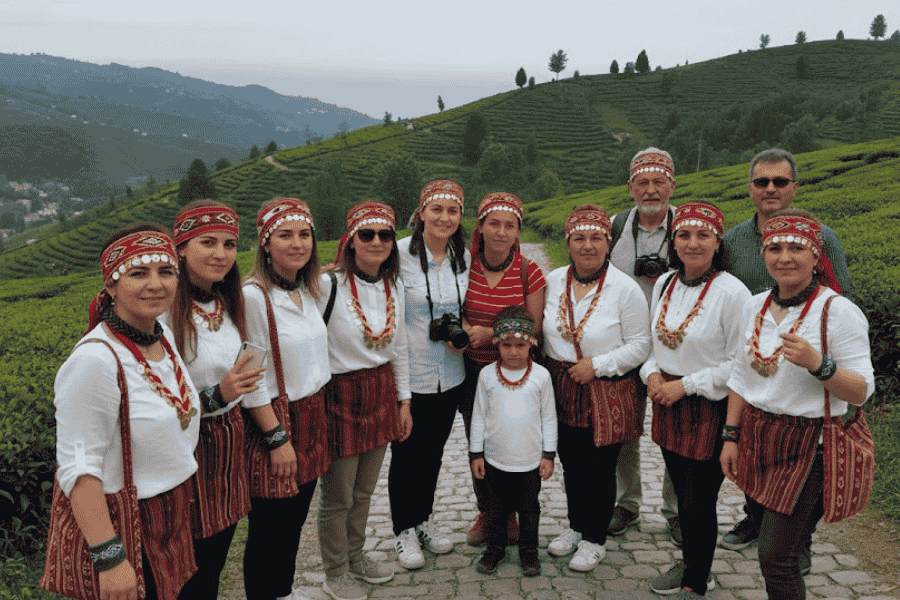 Karadeniz gezisinde Rize keşan aksesuarları takan, geleneksel kıyafetlerle doğa içinde poz veren grup