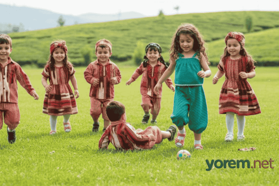 Karadeniz yaylasında keşan elbiseler giyerek çimlerde oynayan, geleneksel kıyafetli neşeli çocuklar